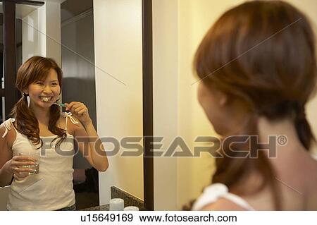 Young woman brushing her teeth View Large Photo Image Stock Photo - Young woman brushing her teeth . Fotosearch