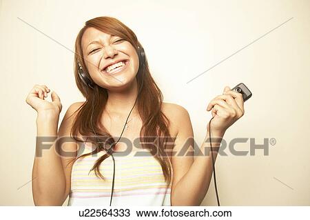 Stock Image - Young woman dancing to music . Fotosearch