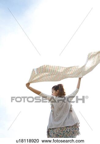 Stock Image - Young woman feeling the wind. Fotosearch