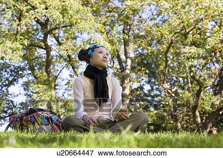 Stock Photo - Young Woman Having Lunch in Park. Fotosearch