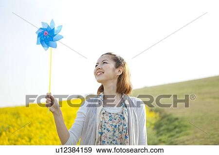 Young woman holding pinwheel View Large Photo Image Stock Photo - Young woman holding pinwheel. Fotosearch