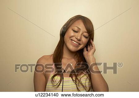 Young woman listening to music View Large Photo Image Stock Image - Young woman listening to music. Fotosearch