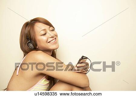 Stock Photography - Young woman listening to music. Fotosearch