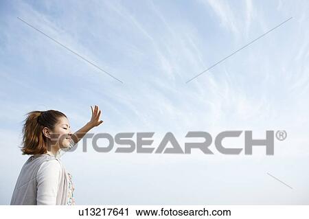 Young woman looking at sun View Large Photo Image Stock Image - Young woman looking at sun. Fotosearch