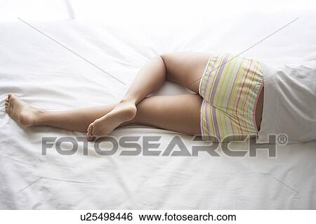 Young woman lying down on bed sleeping View Large Photo Image Stock Photograph - Young woman lying down on bed sleeping. Fotosearch