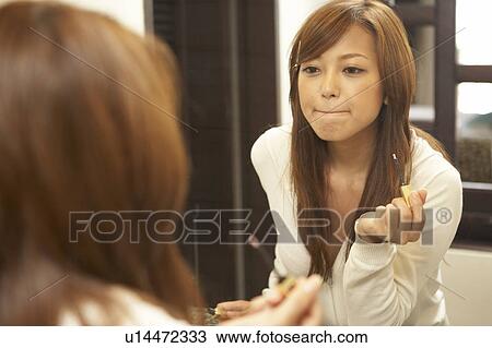 Young woman putting lip gloss on View Large Photo Image Stock Image - Young woman putting lip gloss on. Fotosearch