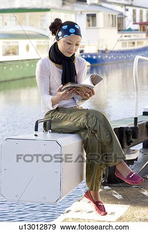 Stock Photo - Young Woman Reading Magazine in Boat. Fotosearch