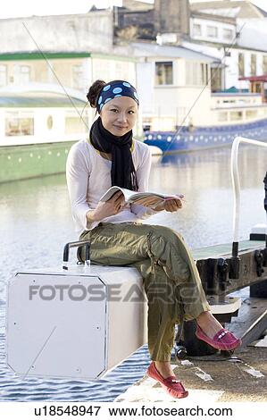 Stock Photo - Young Woman Reading Magazine in Boat. Fotosearch