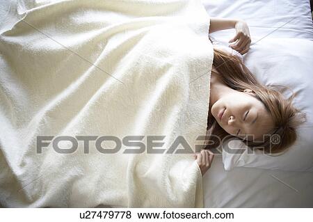 Young woman sleeping in bed View Large Photo Image Stock Photo - Young woman sleeping in bed. Fotosearch