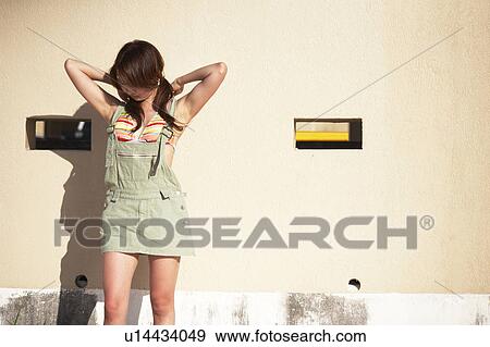 Stock Photo - Young woman standing by the wall, Guam, USA. Fotosearch