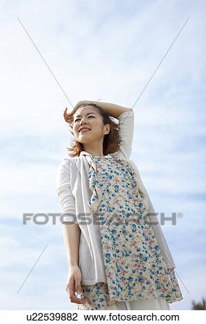 Young woman standing with hand raised View Large Photo Image Stock Image - Young woman standing with hand raised. Fotosearch