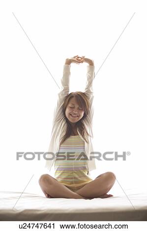 Young woman stretching on bed View Large Photo Image Stock Image - Young woman stretching on bed. Fotosearch