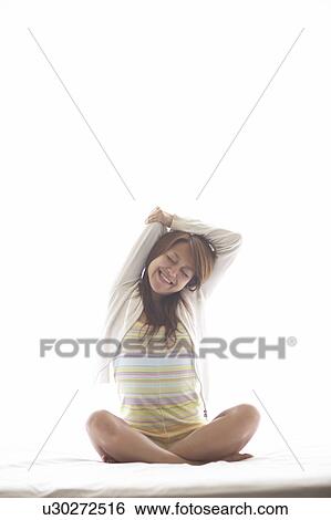 Young woman stretching on bed View Large Photo Image Stock Photograph - Young woman stretching on bed. Fotosearch