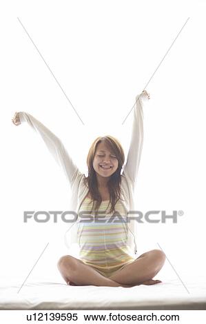 Young woman stretching on bed View Large Photo Image Stock Photography - Young woman stretching on bed. Fotosearch