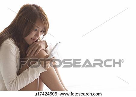 Young woman texting a message View Large Photo Image Stock Photograph - Young woman texting a message . Fotosearch