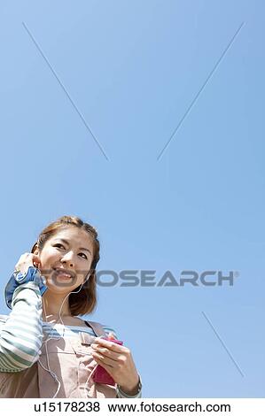 Stock Photo - Young woman with MP3 player. Fotosearch