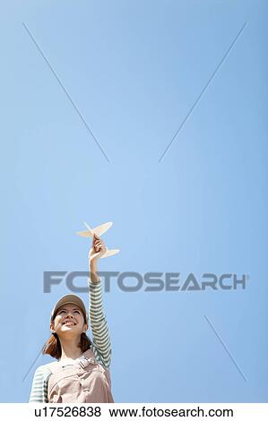 Stock Photo - Young woman with paper airplane. Fotosearch