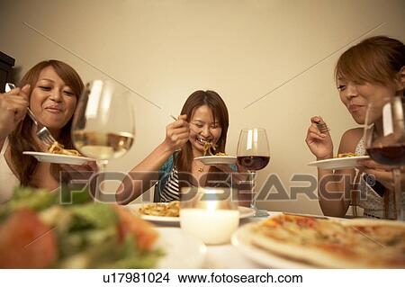 Young women eating dinner View Large Photo Image Picture - Young women eating dinner. Fotosearch