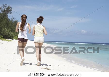 Young women jogging on beach, Guam USA View Large Photo Image Picture - Young women jogging on beach, Guam USA. Fotosearch