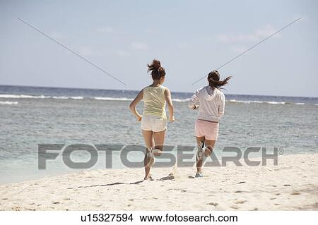 Young women jogging on beach, Guam USA View Large Photo Image Picture - Young women jogging on beach, Guam USA. Fotosearch