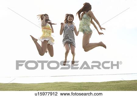 Young women jumping in mid-air, Guam, USA View Large Photo Image Stock Image - Young women jumping in mid-air, Guam, USA. Fotosearch