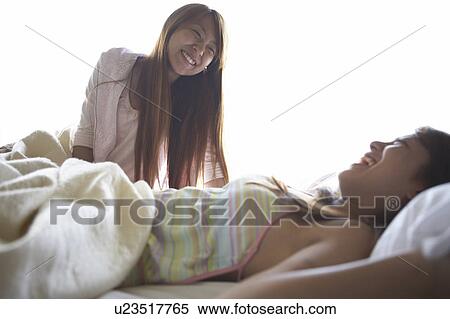 Stock Photography - Young women on bed talking . Fotosearch