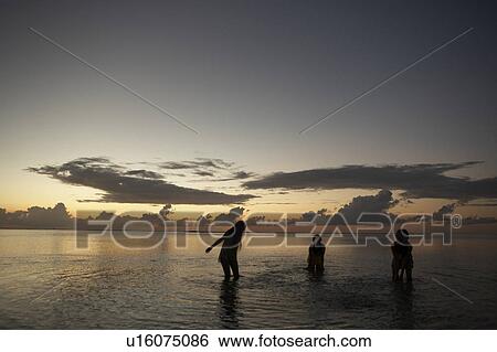 Stock Photograph - Young women playing in water, Guam, USA. Fotosearch