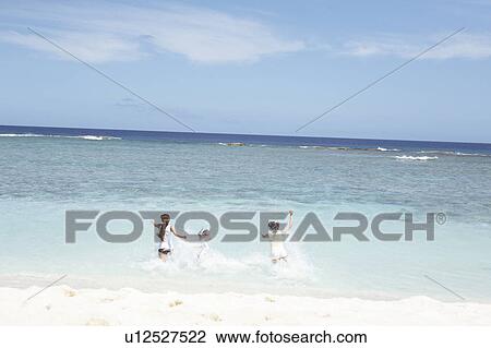 Young women running into the sea, Guam, USA View Large Photo Image Stock Image - Young women running into the sea, Guam, USA. Fotosearch