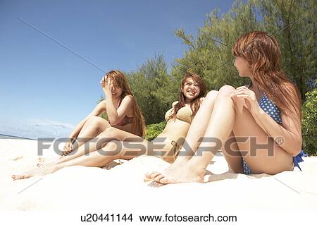 Young women sitting on beach and talking, Guam, USA View Large Photo Image Picture - Young women sitting on beach and talking, Guam, USA. Fotosearch