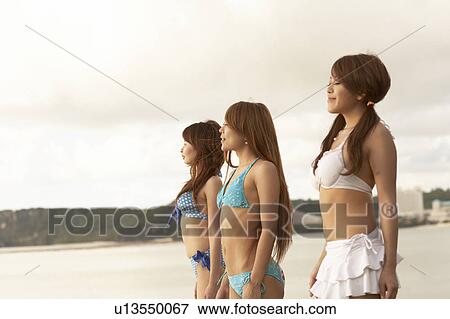 Stock Photo - Young women standing in bikini, Guam, USA. Fotosearch