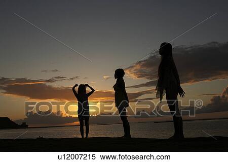 Young women standing on beach at dusk, Guam, USA View Large Photo Image Stock Photography - Young women standing on beach at dusk, Guam, USA. Fotosearch