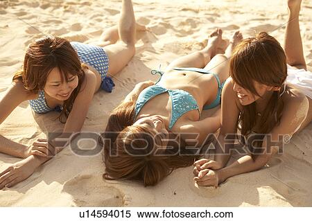Young women sunbathing on beach, Guam, USA View Large Photo Image Stock Photography - Young women sunbathing on beach, Guam, USA. Fotosearch