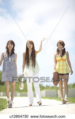 Young women walking on street, Guam, USA View Large Photo Image Stock Image - Young women walking on street, Guam, USA. Fotosearch