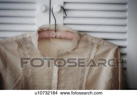Picture - Blouse hanging on wardrobe door. Fotosearch