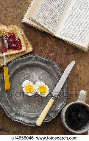 Stock Photograph - Boiled eggs and toast on table with book. Fotosearch
