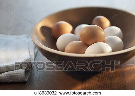 Stock Image - Bowl of raw eggs on table. Fotosearch