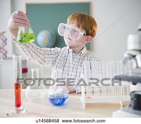 Boy (8-9) holding chemical flask in science lab View Large Photo Image Stock Photo - Boy (8-9) holding chemical flask in science lab. Fotosearch