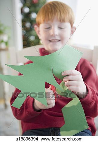 Boy (8-9) making Christmas tree decoration View Large Photo Image Picture - Boy (8-9) making Christmas tree decoration. Fotosearch
