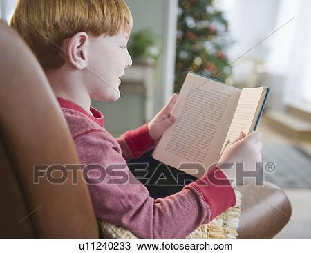 Boy (8-9) reading book on Christmas Eve View Large Photo Image Stock Image - Boy (8-9) reading book on Christmas Eve. Fotosearch