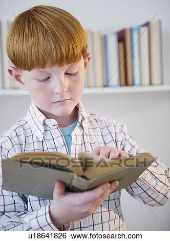 Stock Photograph - Boy (8-9) reading book. Fotosearch