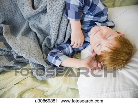 Boy (8-9) sleeping in bed View Large Photo Image Stock Image - Boy (8-9) sleeping in bed. Fotosearch