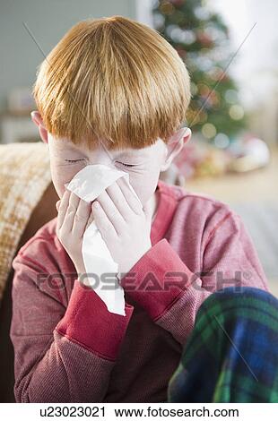 Boy (8-9) Sneezing into tissue View Large Photo Image Stock Image - Boy (8-9) Sneezing into tissue. Fotosearch