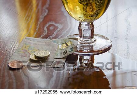 Stock Photography - British currency and beer on table. Fotosearch