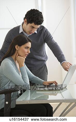 Stock Photo - Business man and woman using computer in office. Fotosearch