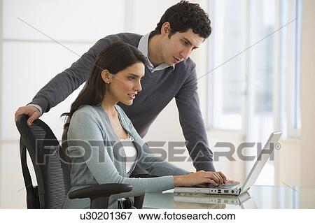 Business man and woman using computer in office View Large Photo Image Stock Photo - Business man and woman using computer in office. Fotosearch