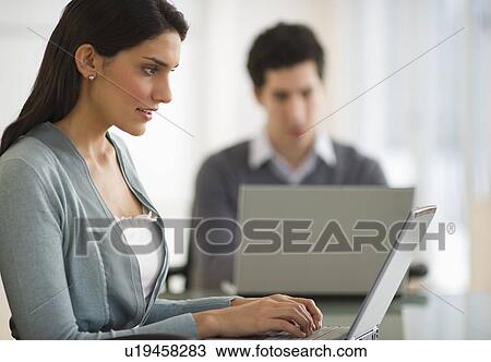 Business man and woman using laptops in office View Large Photo Image Stock Image - Business man and woman using laptops in office. Fotosearch