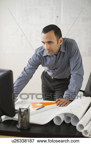 Stock Photo - Business man studying blueprints. Fotosearch