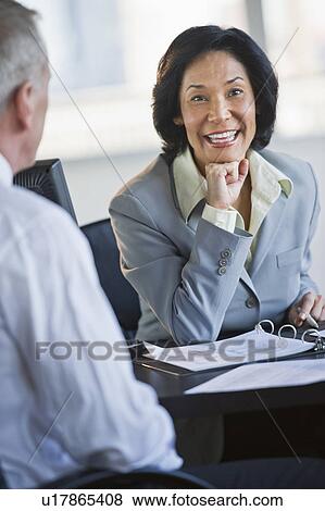 Stock Photo - Businessman and businesswoman at meeting. Fotosearch