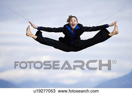 Stock Image - Businessman mid-air doing splits. Fotosearch