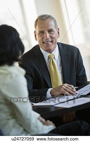 Stock Photo - Businesswoman and businessman at meeting. Fotosearch